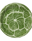 A round green disposable china plate designed to resemble a cabbage leaf.